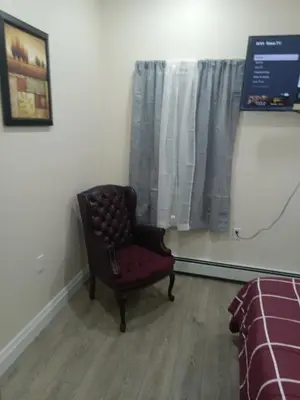 a chair sitting in a room with a window at Luxury private room bath WiFi in Troy