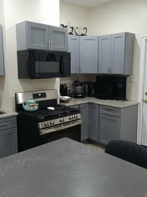 a kitchen with white cabinets and a stove top oven at Luxury private room bath WiFi in Troy
