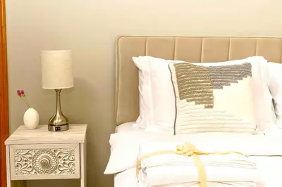 a bed with white sheets and a lamp on a night stand at Secluded Catskills Cabin , Cozy and Private in Acra
