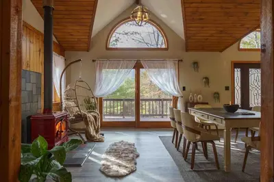 a dining room with a table and a fireplace at Secluded Catskills Cabin , Cozy and Private in Acra
