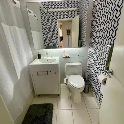 a bathroom with a toilet and a sink and a mirror at Manhattan Oasis in Peekskill
