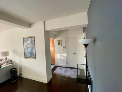 a living room with a glass table and a hallway at Manhattan Oasis in Peekskill