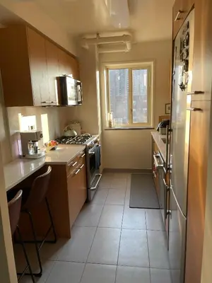 a small kitchen with a refrigerator and a window at Manhattan Oasis in Peekskill