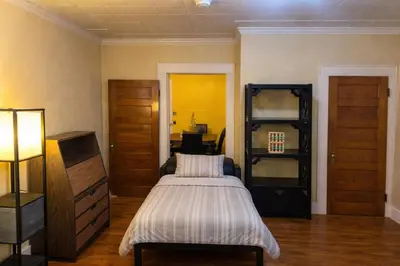 a bedroom with a bed and a dresser in it at Credo Ok! Party Room in Bridgeport