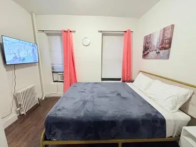 a bedroom with a large bed with red curtains at The W50 Metropolitan in New York