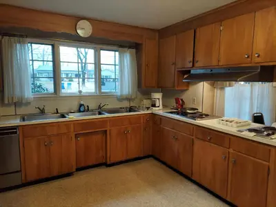 a kitchen with wooden cabinets and a sink and a window at Eve's Country Retreat