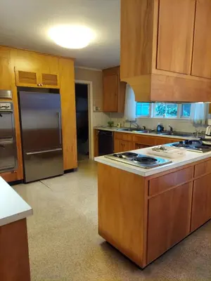 a kitchen with wooden cabinets and a stove top oven at Eve's Country Retreat