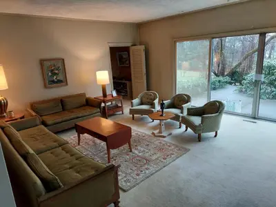 a living room with couches and chairs and a large window at Eve's Country Retreat