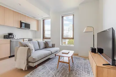 a living room with a couch and a table at Blueground South Williamsburg rooftop nr Domino Park NYC-2131 in Brooklyn