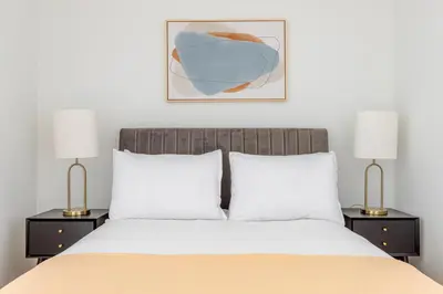 a bedroom with a white bed with two lamps at Blueground South Williamsburg rooftop nr Domino Park NYC-2131 in Brooklyn
