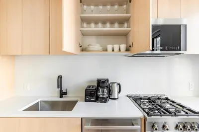 a kitchen with a sink and a stove top oven at Blueground South Williamsburg rooftop nr Domino Park NYC-2131 in Brooklyn