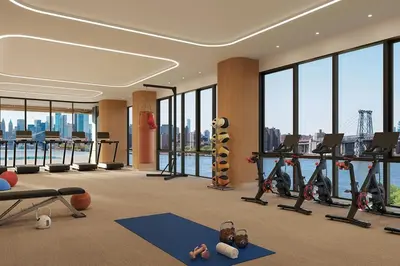 a gym with exercise equipment and a view of the city at Blueground South Williamsburg rooftop nr Domino Park NYC-2131 in Brooklyn