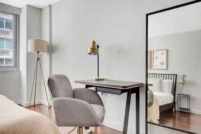 a bedroom with a mirror and a desk and a bed at Blueground Murray Hill fitness center nr East River NYC-695 in New York