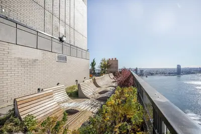 a row of benches next to a building next to the water at Blueground Murray Hill fitness center nr East River NYC-695 in New York