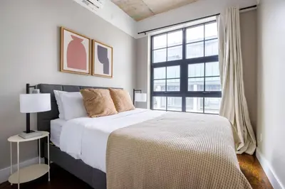 a bedroom with a large bed and a large window at Blueground Williamsburg rooftop nr East River NYC-1992 in Brooklyn