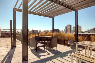 a patio with tables and chairs and a view of the city at Blueground Williamsburg rooftop nr East River NYC-1992 in Brooklyn