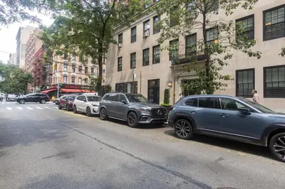 a row of cars parked on the side of a street at Blueground Carnegie Hill fitness center nr Central Park NYC-1967 in New York