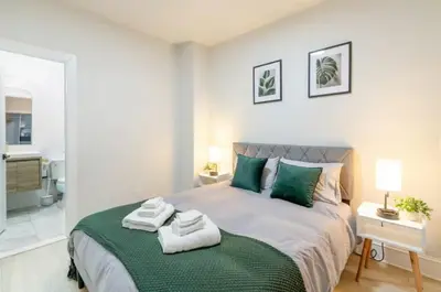a bedroom with a large bed with towels on it at Chic 3BR-4BD-3Bath Oasis with Backyard Near NYC in Jersey City