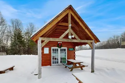 a log cabin with a picnic table in the snow at Greer Court Retreat in Wilmington