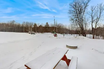 a bench sitting in the snow in a park at Greer Court Retreat in Wilmington