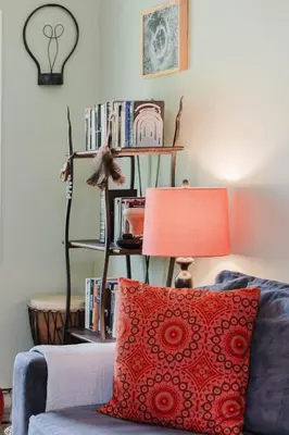 a living room with a red pillow and a shelf with books at Cozy Townhouse Near Hunter Mountain in Tannersville