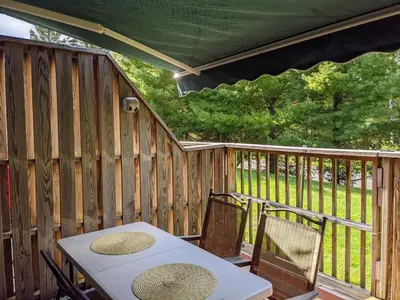 a patio with a table and chairs on a deck at Cozy Townhouse Near Hunter Mountain in Tannersville