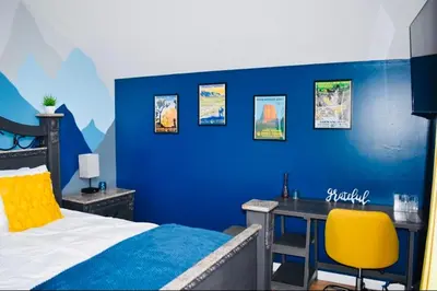 a bedroom with a blue wall with a desk and a bed at LUX Poconos Home MINS to Lehigh Valley Hosp in Pocono Summit
