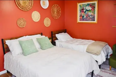 two beds in a room with orange walls at LUX Poconos Home MINS to Lehigh Valley Hosp in Pocono Summit