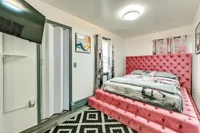 a bedroom with a pink bed with a red headboard at Walk to Shops, Parks and Restaurants Teaneck Escape in Teaneck