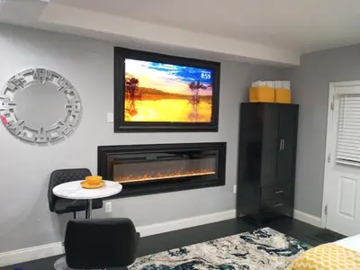 a living room with a fireplace and a tv at Nectar of the Gardens in Newark