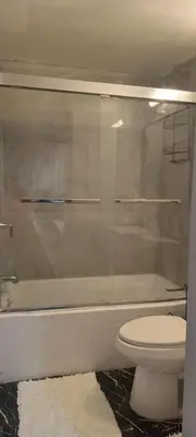 a bathroom with a toilet and a glass shower at Nectar of the Gardens in Newark