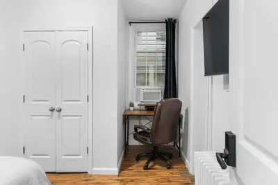 a bedroom with a desk and a chair next to a window at Queen Bedroom w Ensuite Bathroom - Mins from NYC in Jersey City
