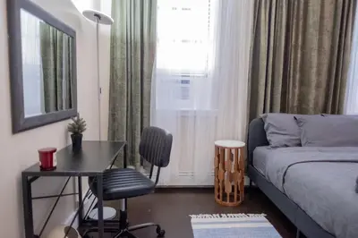 a small room with a bed and a table and a desk at Brand New 3BR 2BA next to Central Park, elevator in New York