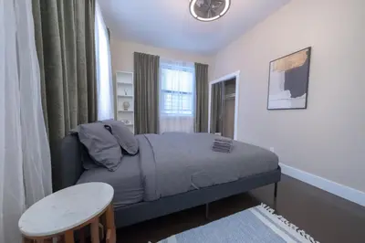 a small bedroom with a bed and a table at Brand New 3BR 2BA next to Central Park, elevator in New York