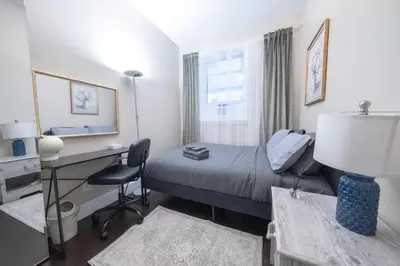 a hotel room with a bed and a desk and a desk at Brand New 3BR 2BA next to Central Park, elevator in New York