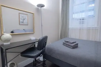 a bedroom with a desk and a bed and a window at Brand New 3BR 2BA next to Central Park, elevator in New York