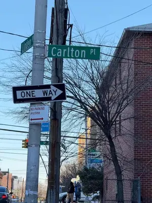 a one way sign on a pole on a street at Cozy private room in downtown Flushing in Queens