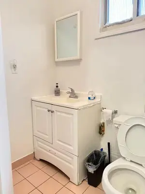 a bathroom with a white sink and a toilet at Cozy private room in downtown Flushing in Queens