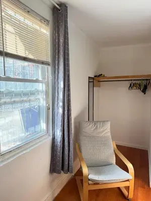 a chair sitting in a room next to a window at Cozy private room in downtown Flushing in Queens