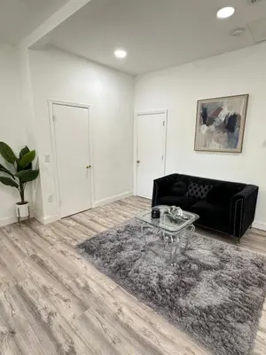 a living room with a black couch and a table at Beautiful and comfortable room, close to New York Hermosa y cómoda habitación, cerca a New York in West New York