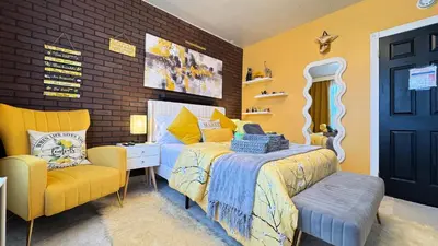 a yellow bedroom with a bed and a chair at Sunshine Dream - Deluxe Double Room in Private House - NYC in Sunnyside