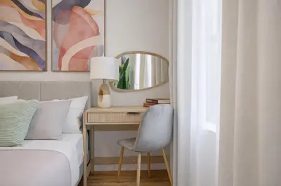 a bedroom with a bed and a desk with a mirror at Bright & Cozy 2BD in Upper East Side in New York