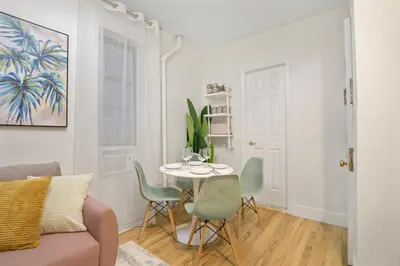 a living room with a table and chairs at Bright & Cozy 2BD in Upper East Side in New York