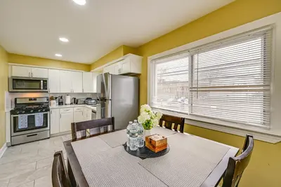 a dining room with a table and a kitchen at Walkable Jersey City Stay Near Parks and Dining! in Jersey City