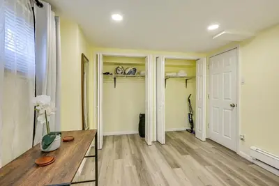 a living room with a wooden table and a hallway at Walk to Lincoln Park Jersey City Commuter Apt! in Jersey City