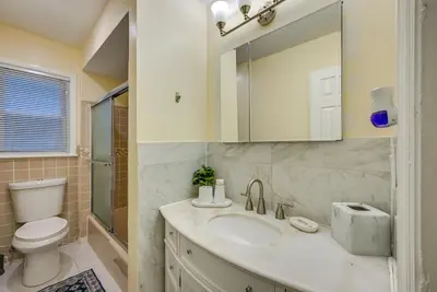 a bathroom with a sink and a toilet and a mirror at 6 Mi to Lower Manhattan Pet-Friendly Apt! in Jersey City