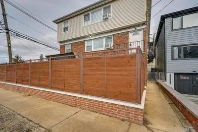 a wooden fence in front of a house at 6 Mi to Lower Manhattan Pet-Friendly Apt! in Jersey City