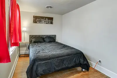 a bedroom with a black bed in a white room at Work and Study Binghamton Apt 2 Mi to Downtown in Binghamton