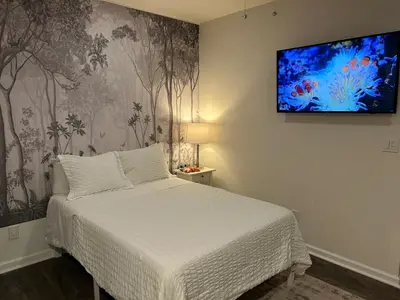 a bedroom with a bed and a tv on the wall at Private, Cozy Studio in Downtown Stamford, CT in Stamford