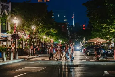 a group of people crossing a city street at night at Private, Cozy Studio in Downtown Stamford, CT in Stamford